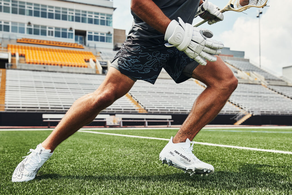 Grant Ament, a professional athlete, during a peak action moment that shows a close up of New Balance's latests footwear and sports cleat for lacrosse. Photographed and produced by Unrivaled in Baltimore, MD.