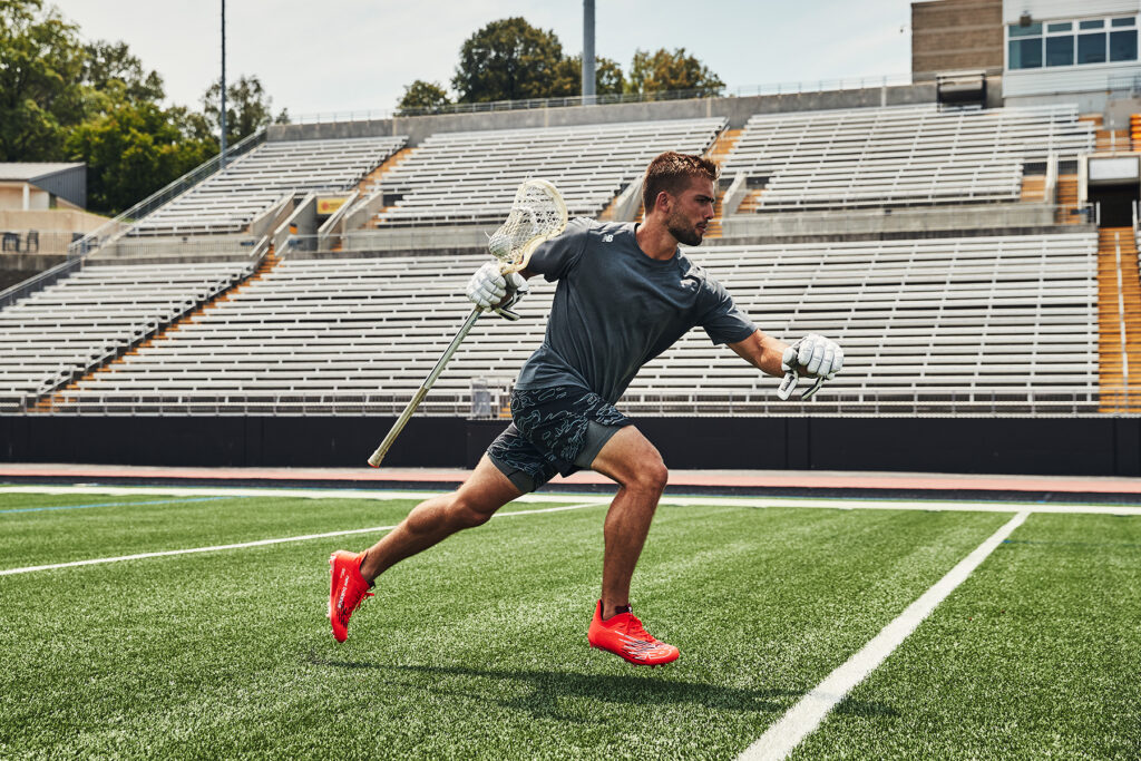 Grant Ament, a professional athlete, during a peak action moment that shows a close up of New Balance's latests footwear and sports cleat for lacrosse. Photographed and produced by Unrivaled in Baltimore, MD.