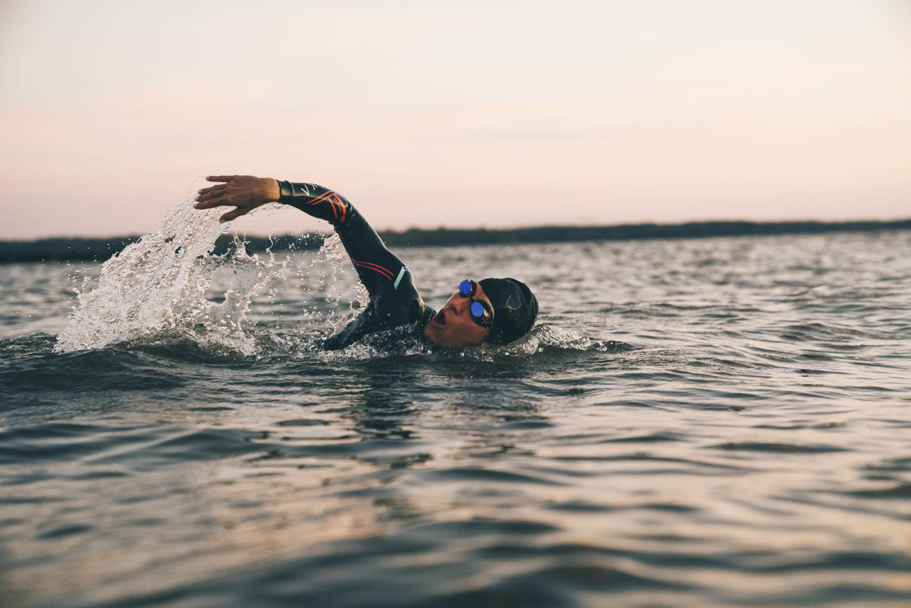 Influencer marketing for sports and apparel brands in New York City. A swimmer swims in a lake at sunrise.