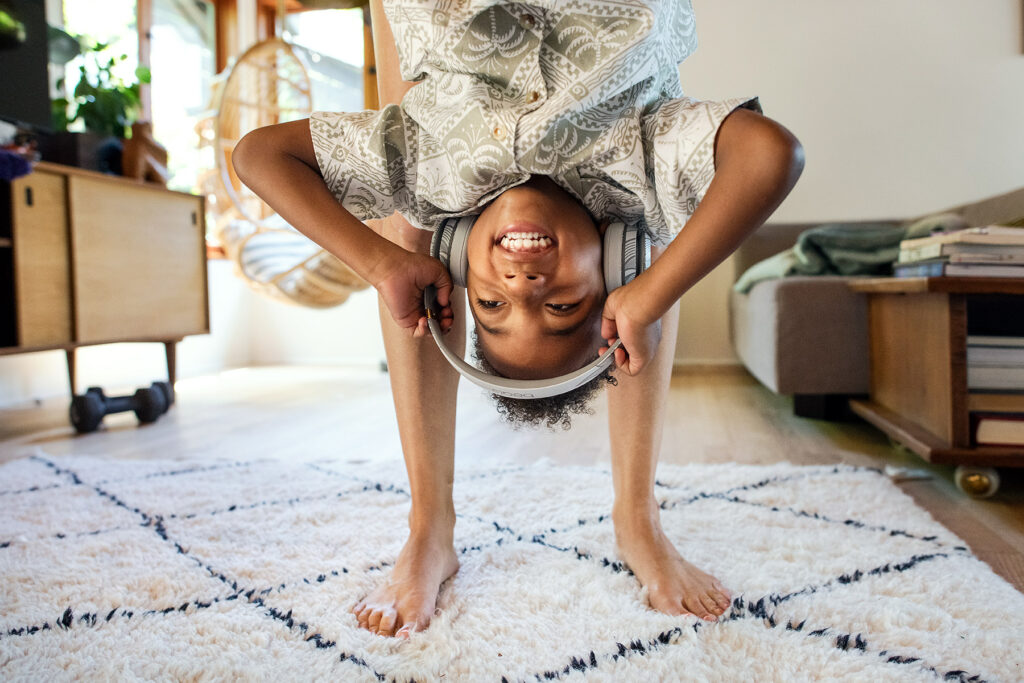 A young boy listens to music on his Beats by Dre while is mother holds him upside down in his Los Angeles living room.