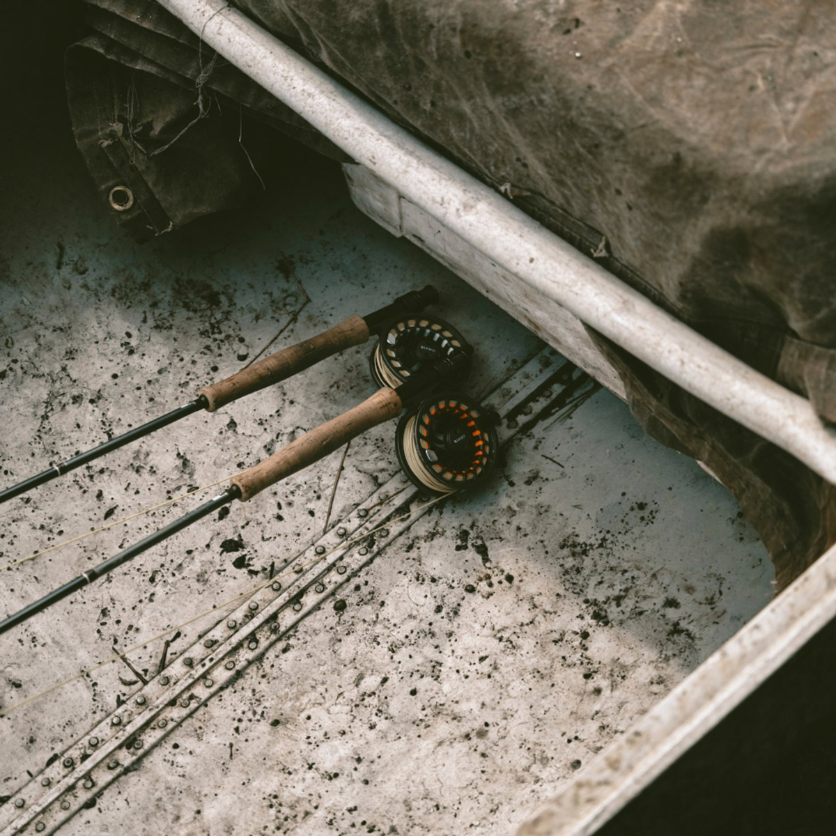 Fly fishing gear sit on the bottom of a boat.