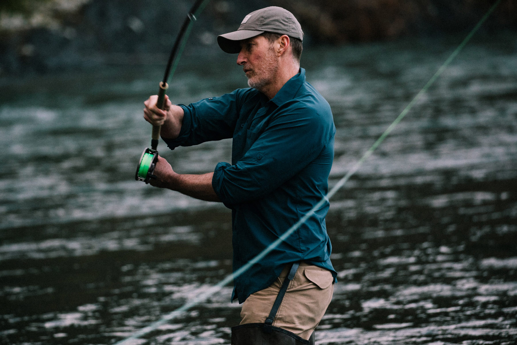 A man fly fishes in a river.