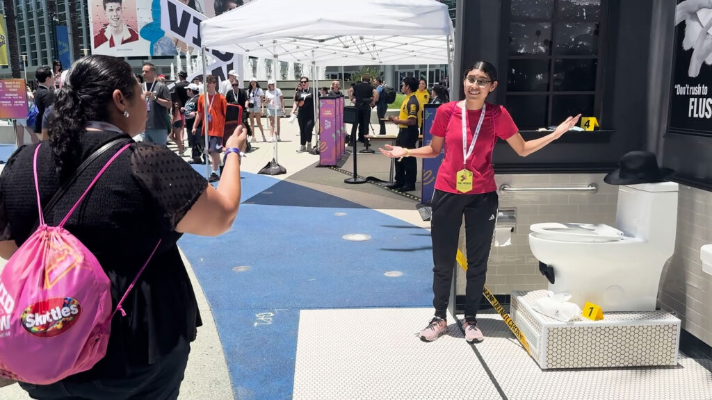 An attendee at Vid Con poses for a picture with an exhibit designed and fabricated by the team at Unrivaled, a creative production company.