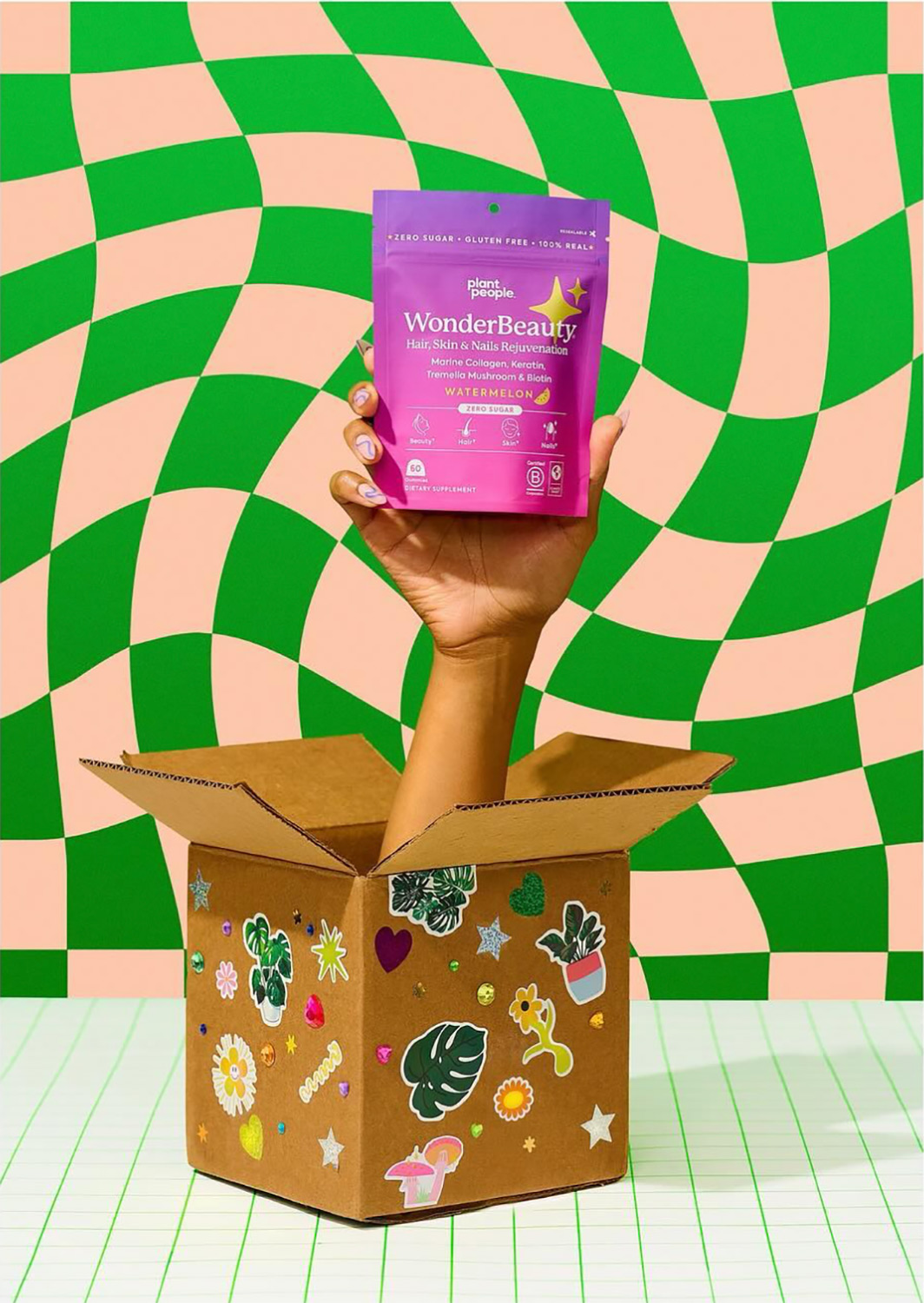 Los Angeles food and product photographer photographed Plant People for the latest social media ad campaign. In the image, we see a hand popping out of a box, holding the product, Wonder Beauty, against a bright green and pink checkered background.